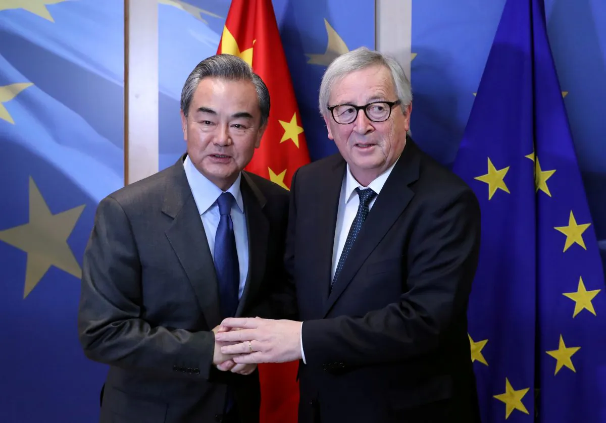 Chinese Foreign Minister Wang Yi is welcomed by European Commission President Jean-Claude Juncker ahead of a meeting in Brussels, Belgium on March 18, 2019. (Yves Herman/Reuters)
