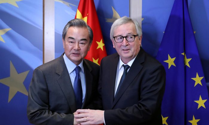 Chinese Foreign Minister Wang Yi is welcomed by European Commission President Jean-Claude Juncker ahead of a meeting in Brussels, Belgium on March 18, 2019. (Yves Herman/Reuters)