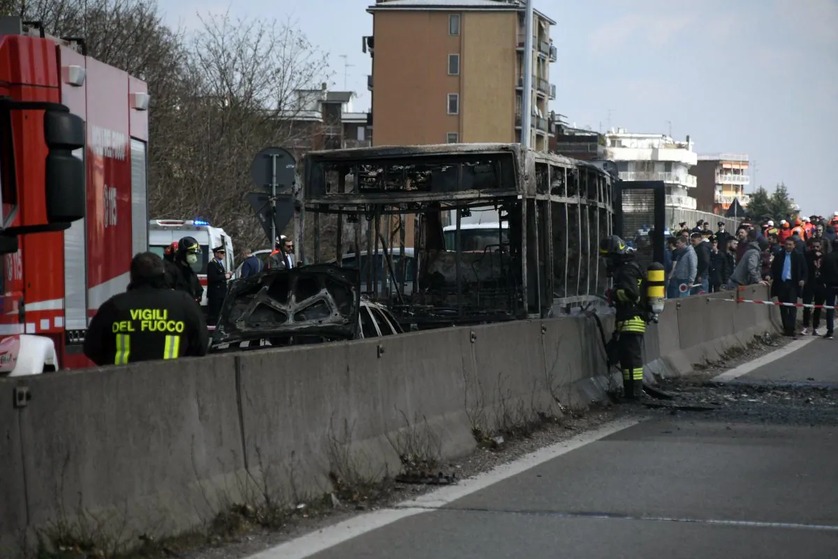 Firefighters stand by the gutted remains of a bus in San Donato Milanese, near Milan, Italy, on March 21, 2019. (Daniele Bennati/ANSA via AP)