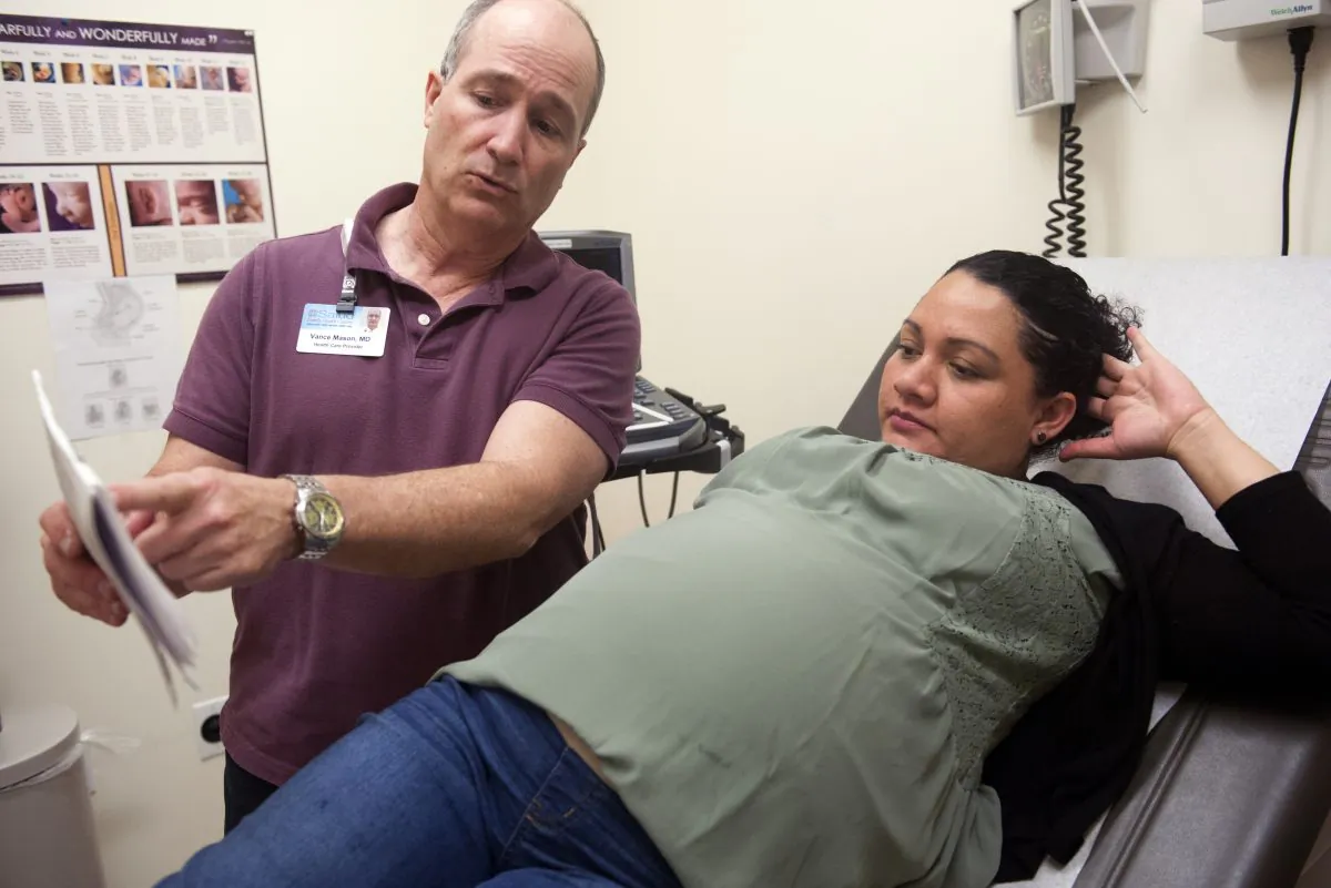 Dr. Vance Mason and Ariel Zetina discuss her pregnancy during a checkup at Inner City Health Center in Denver, Colorado on March 15, 2017. (Jason Connolly/AFP/Getty Images)