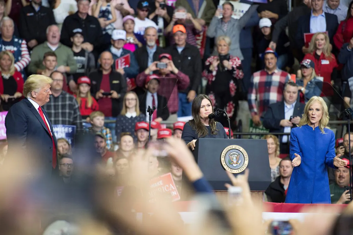President Donald Trump (L) looks on as White House Press Sarah Huckabee Sanders speaks and Kellyanne Conway cheers at a Make America Great Again rally in Fort Wayne, Indiana on Nov. 5, 2018. (JIM WATSON/AFP/Getty Images)