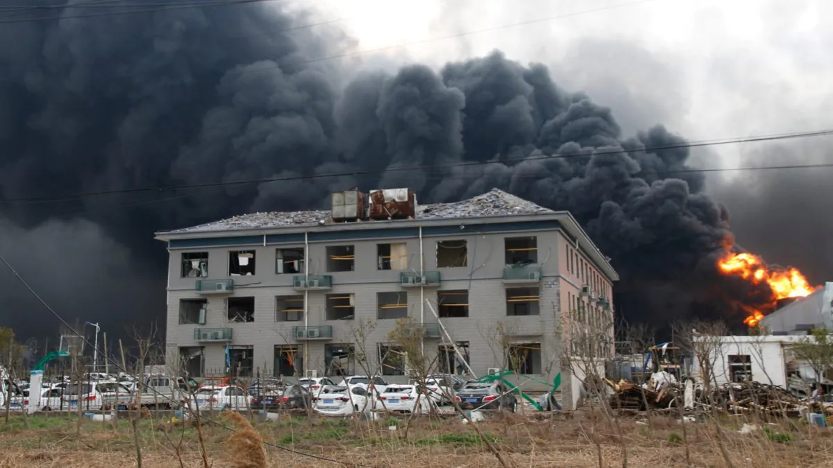 Smoke billows from fire behind a damaged building following an explosion at the pesticide plant owned by Tianjiayi Chemical, in Yancheng, Jiangsu Province, China on March 21, 2019. (Stringer via Reuters)