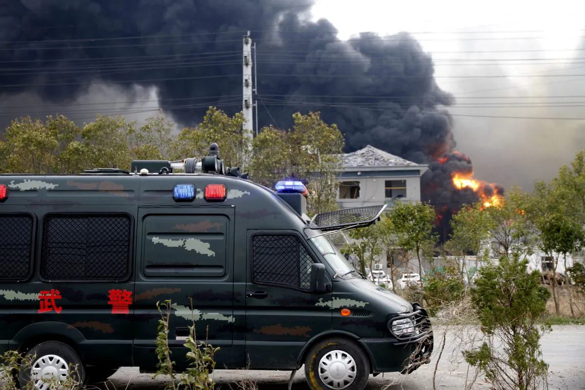 A vehicle of paramilitary police is seen near smoke following an explosion at a chemical industrial park in Yancheng City, Jiangsu Province, China on March 21, 2019. (Stringer via Reuters)