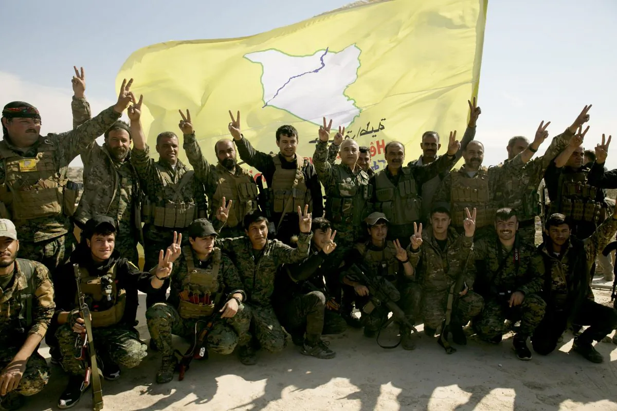 U.S.-backed Syrian Democratic Forces (SDF) fighters pose for a photo on a rooftop overlooking Baghouz, Syria, after the SDF declared the area free of ISIS terrorists after months of fighting on March 23, 2019. (Maya Alleruzzo/Photo via AP)