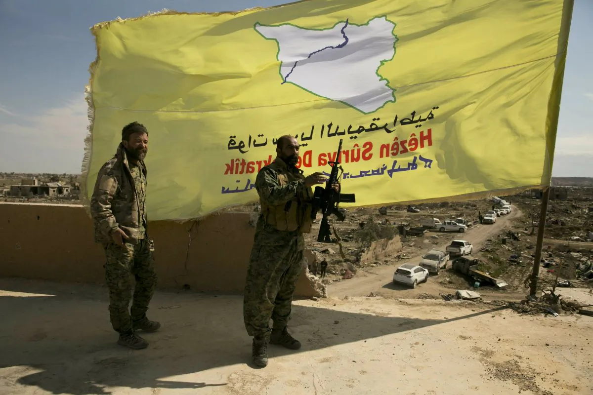 U.S.-backed Syrian Democratic Forces (SDF) fighters pose for a photo on a rooftop overlooking Baghouz, Syria, after the SDF declared the area free of ISIS terrorists after months of fighting on March 23, 2019. (Maya Alleruzzo/Photo via AP)