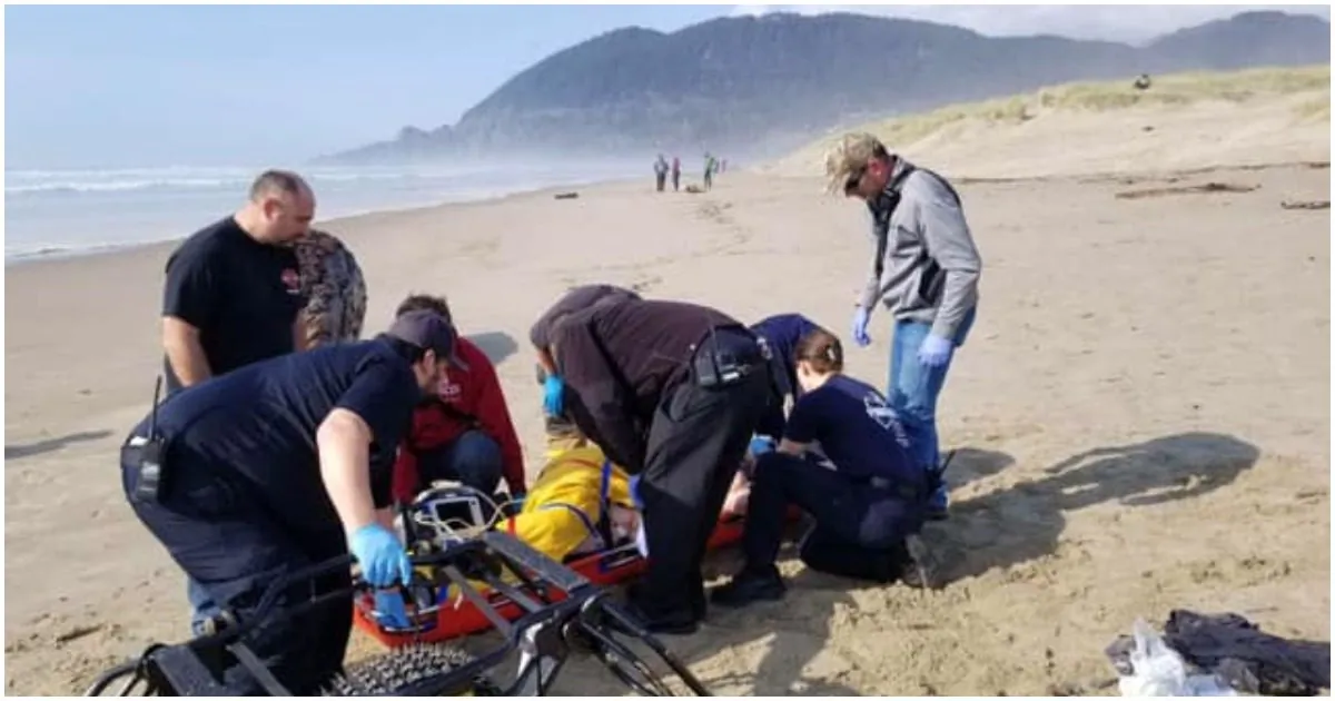 A rescue team attends to a woman hit by a log on  Manzanita Beach, Oregon, on March 23, 2019. (Nehalem Bay Fire & Rescue) 