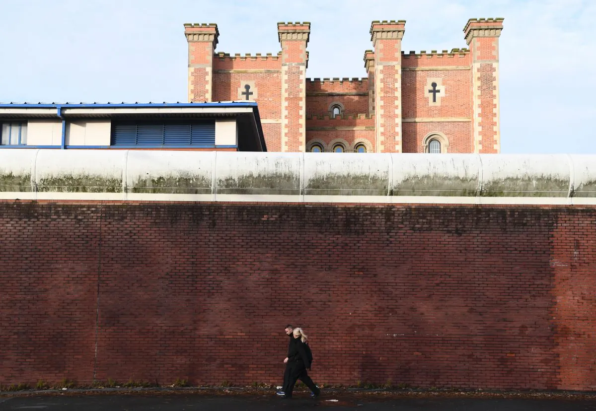 Two people walk alongside the curtain wall of HMP Liverpool, northwest England, on Nov. 15, 2016. (Paul Ellis/AFP/Getty Images)