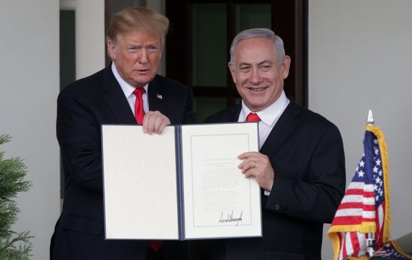 President Donald Trump (left) and Israeli Prime Minister Benjamin Netanyahu show a declaration recognizing Israeli sovereignty over the Golan Heights after meeting outside the West Wing of the White House.