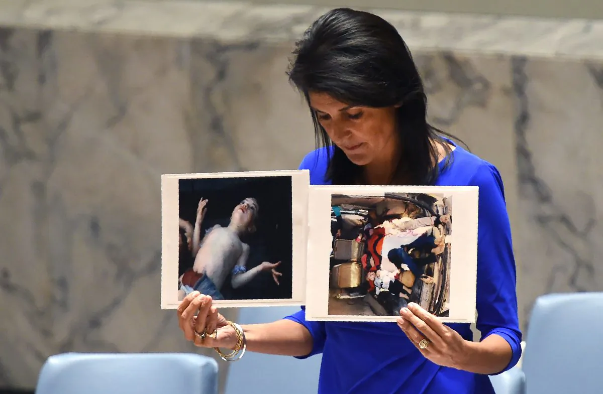 U.S. Ambassador to the UN Nikki Haley holds photos of victims of a suspected chemical attack in Syria, as she speaks as the UN Security Council in New York on April 5, 2017. (TIMOTHY A. CLARY/AFP/Getty Images)