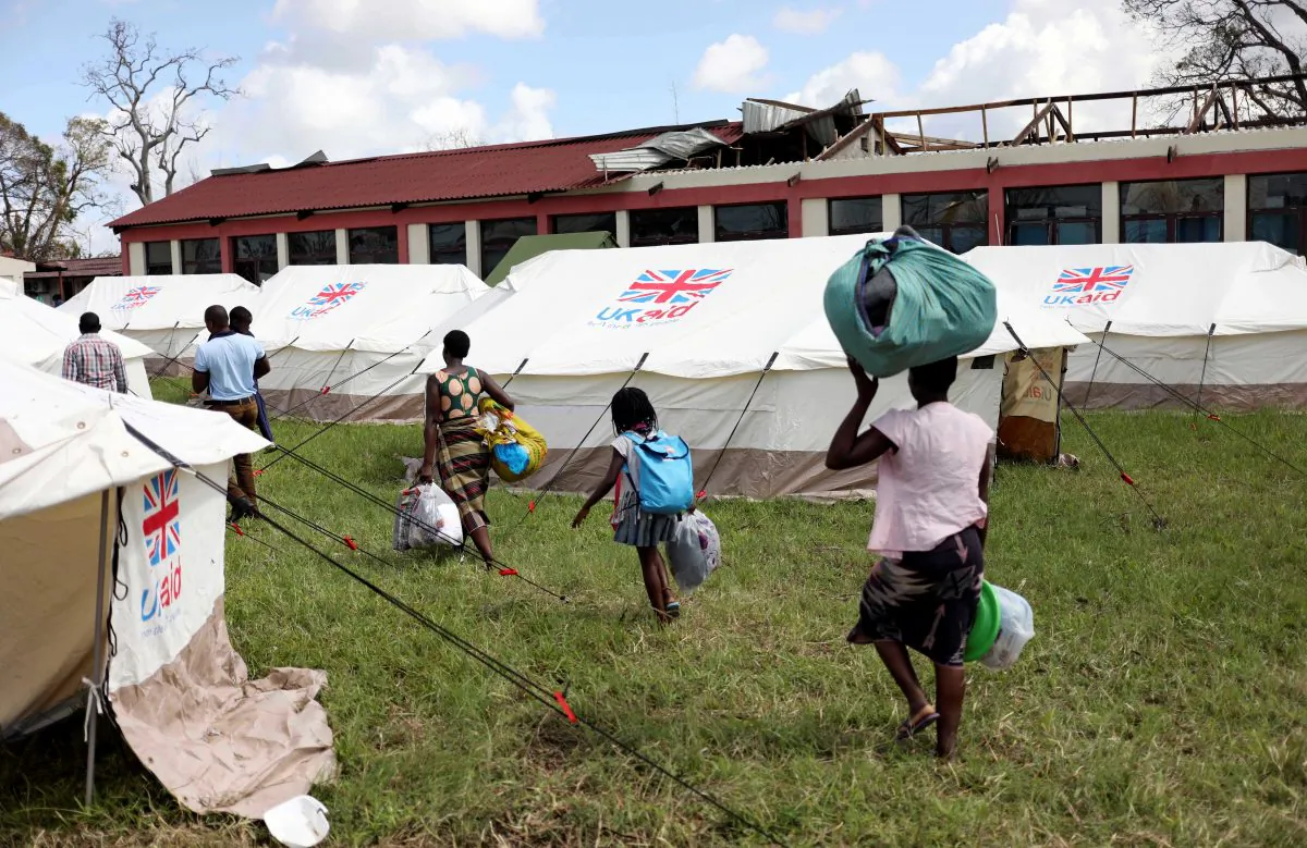 Evacuees from Buzi vilage carry their belongings as they arrive at a displacement center near the aiport, after Cyclone Idai, in Beira, Mozambique, March 25, 2019. REUTERS/Siphiwe Sibeko