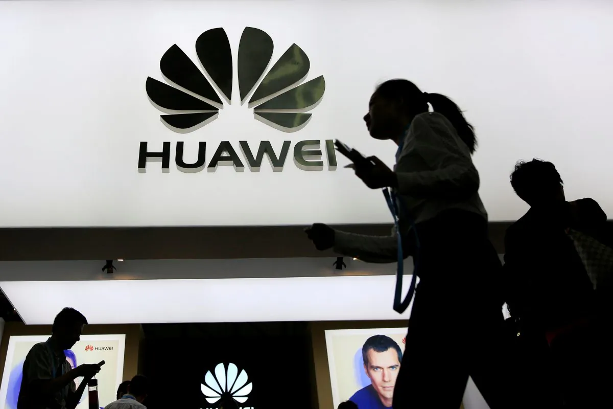 People walk past a sign board of Huawei at CES (Consumer Electronics Show) Asia 2016 in Shanghai, China on May 12, 2016. (Aly Song/Reuters)