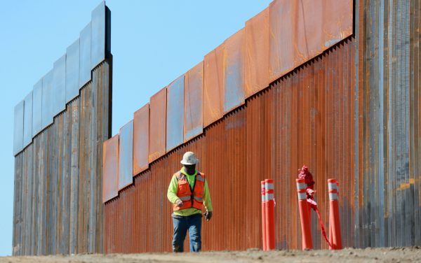 Construction workers build a secondary border wall in Otay Mesa