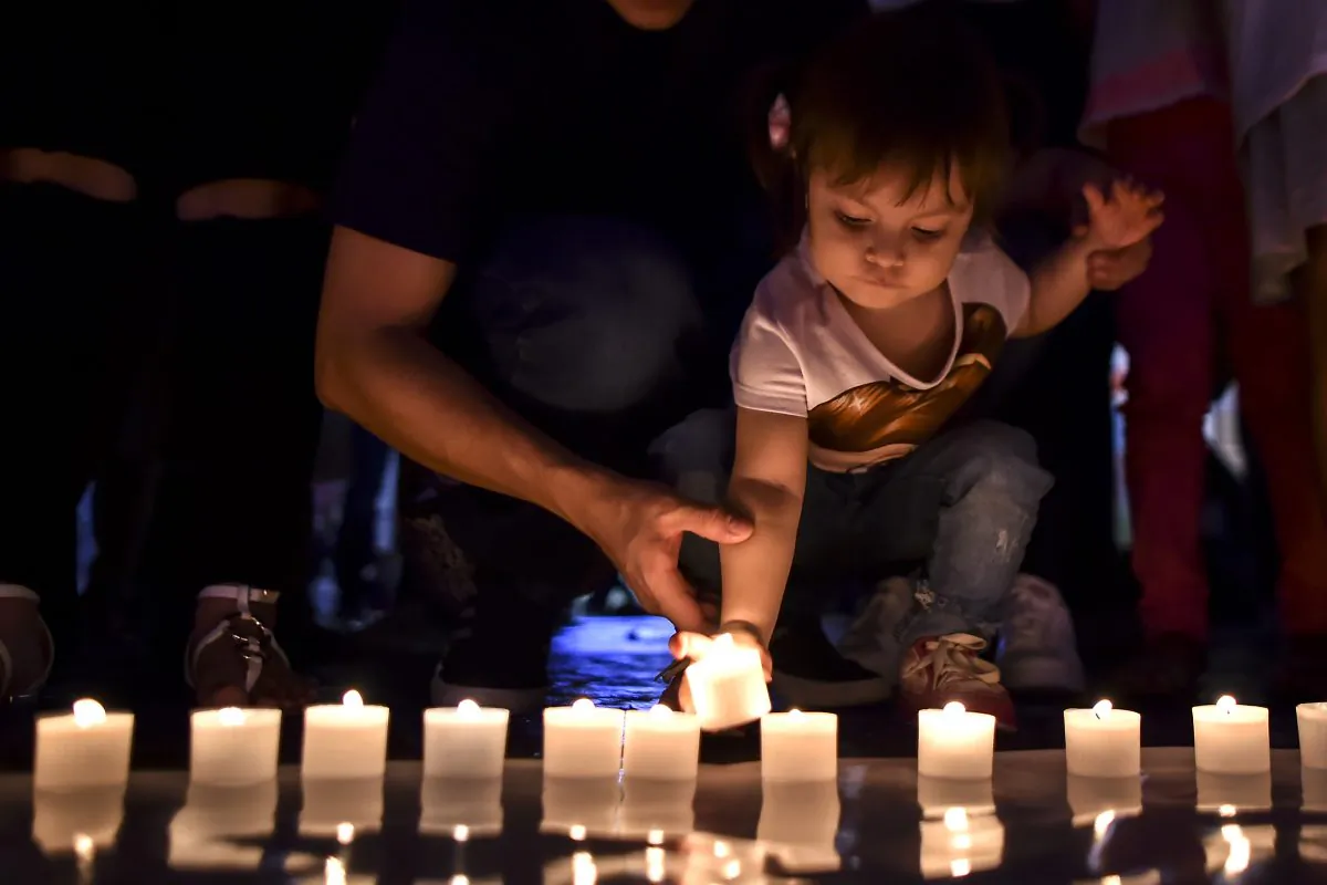 A girl lights candles and form 60+ sign during the Earth Hour environment campaign in Cali, Valle del Cauca department, Colombia, on March 24, 2018.  LUIS ROBAYO/AFP/Getty Images