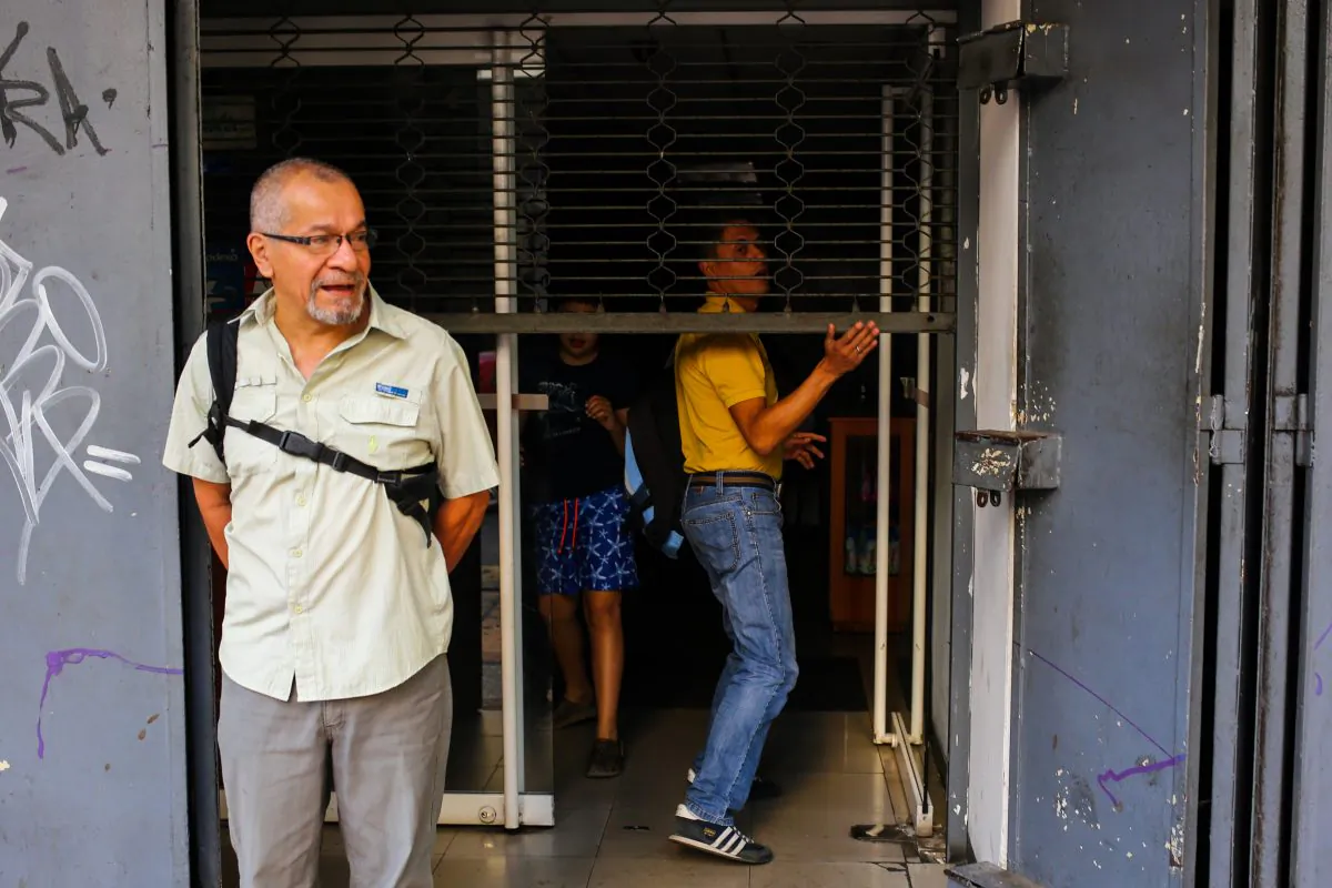 People stand at the entrance of a closed store in Caracas on March 27, 2019 during a power outage in Venezuela . (Cristian Hernandez/AFP/Getty Images)