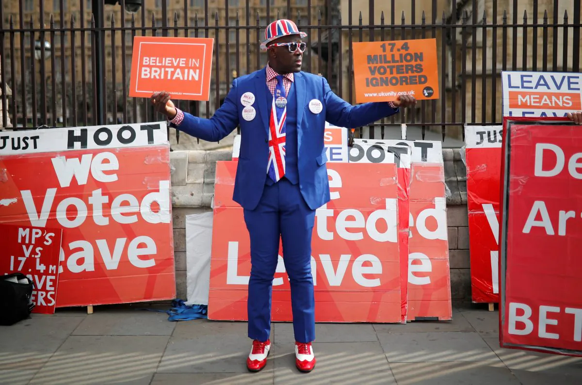 A pro-Brexit supporter holds placards outside the Houses of Parliament, following the Brexit votes the previous evening, in London, Britain, March 28, 2019. REUTERS/Alkis Konstantinidis