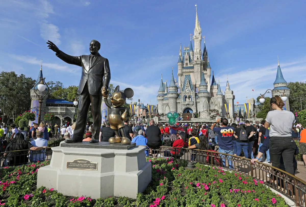 Guests watch a show near a statue of Walt Disney and Micky Mouse in front of the Cinderella Castle at the Magic Kingdom at Walt Disney World in Lake Buena Vista, Fla., on Jan. 9, 2019. (John Raoux/AP Photo)