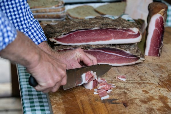 Man cutting Italian speck by hand
