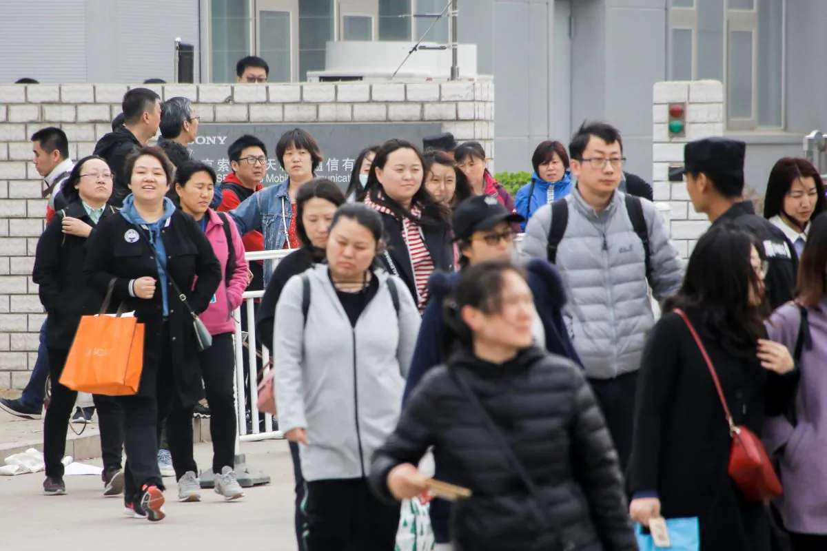 Workers leave a Sony smartphone plant in Beijing on March 27, 2019. (Thomas Peter/Reuters)