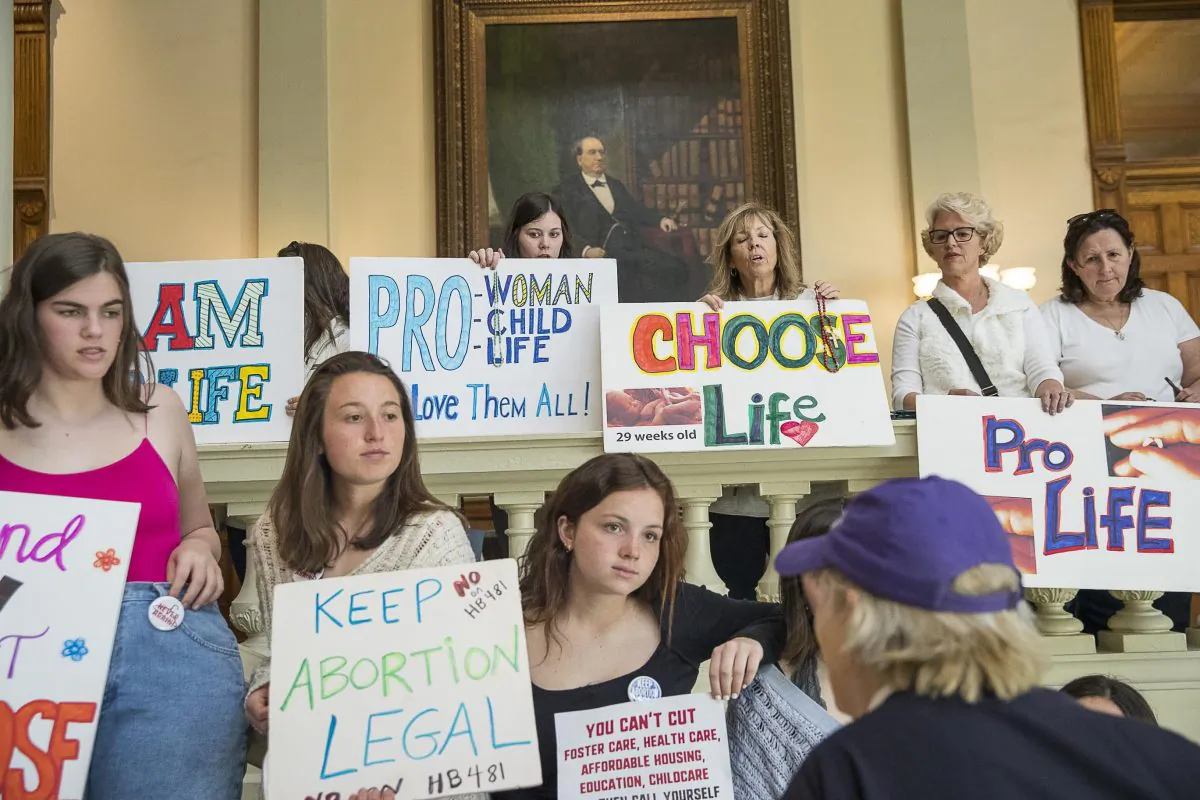 Pro-abortion rights and anti-abortion demonstrators displaying their signs in the lobby of the Georgia State Capitol building during the 35th legislative day at the Georgia State Capitol building in downtown Atlanta on March 22, 2019. (Alyssa Pointer/Atlanta Journal-Constitution/File via AP)