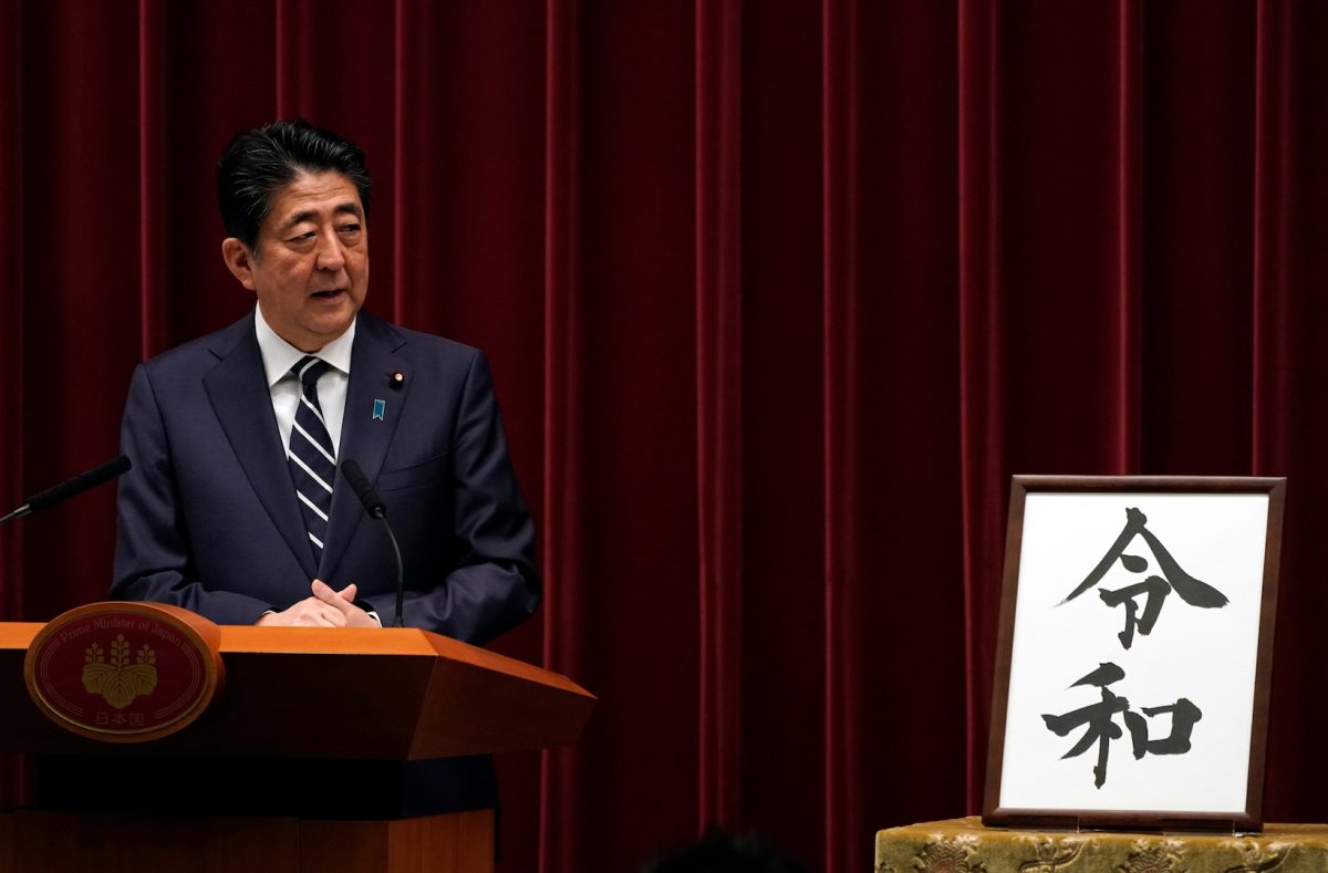 Japan's Prime Minister Shinzo Abe delivers a press conference standing next to the calligraphy 'Reiwa' which was chosen as the new era name at the prime minister's office in Tokyo