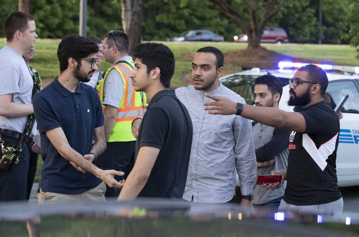 People gather across from the campus of University of North Carolina at Charlotte after a shooting at the school in Charlotte, N.C., on April 30, 2019. (Jason E. Miczek/AP Photo)