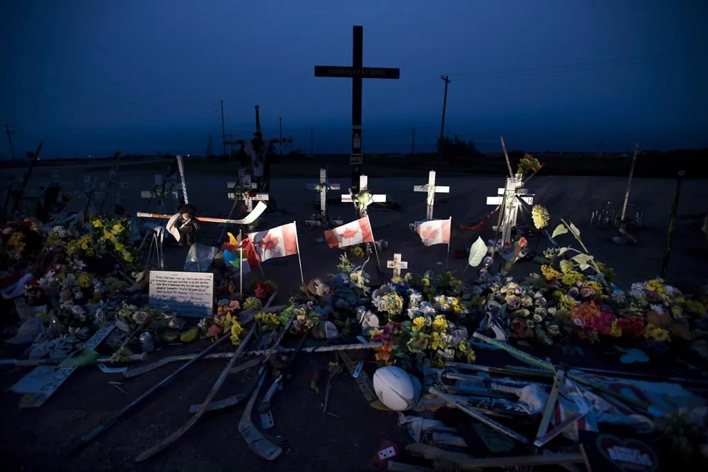 A memorial made of hockey sticks, crosses, and Canadian flags is seen at the crash site of the Humboldt Broncos hockey team near Tisdale, Sask. (Jonathan Hayward/The Canadian Press)