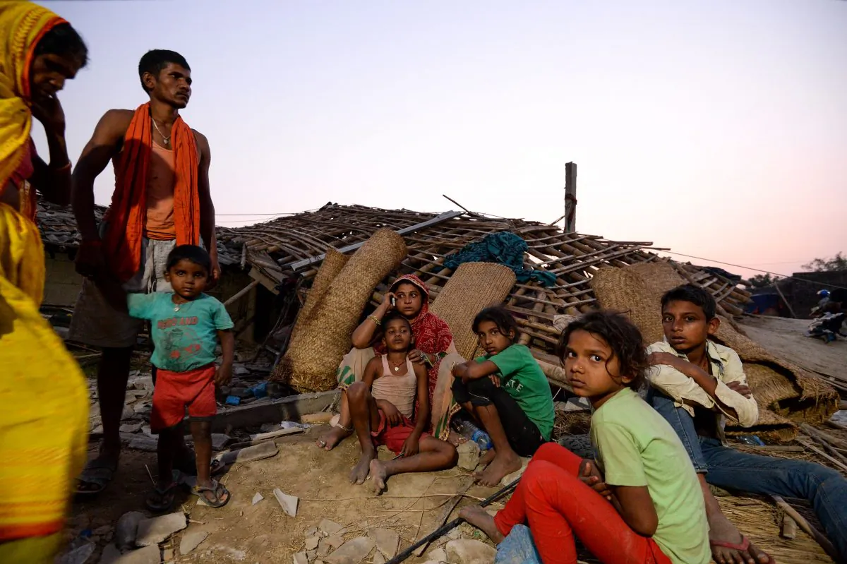 Nepali family members sit next to their damaged houses at Bhaluhi Bharbaliya village in Nepal's southern Bara district near Birgunj on April 1, 2019, the morning after a rare spring storm. (Prakash Mathema/AFP/Getty Images)