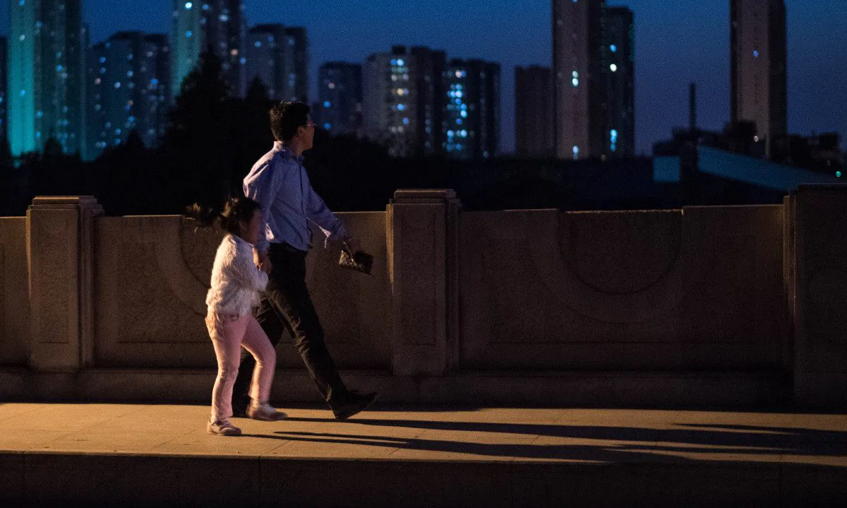 A man and a girl walking on a bridge in Shanghai, China. (Johannes Eisele/AFP/Getty Images)