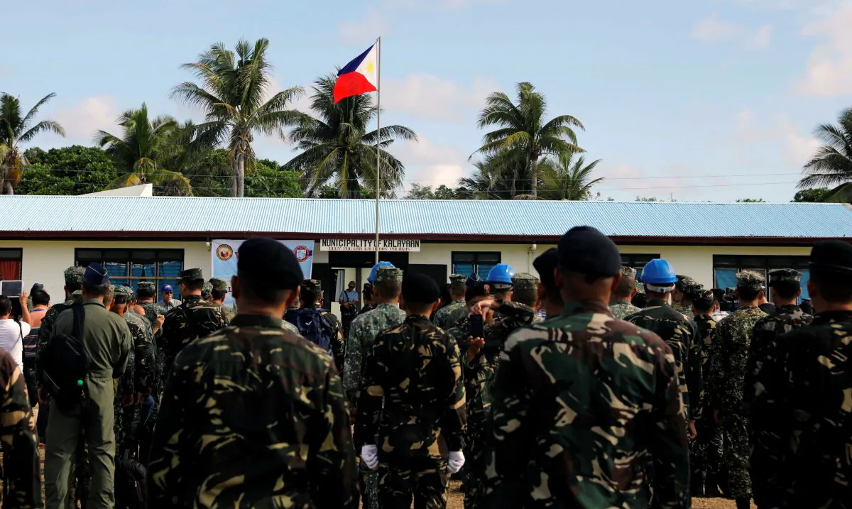A Philippine flag flutters in Philippine occupied (Pagasa) Thitu island, in disputed South China Sea, as soldiers and civilians sing the country's national anthem on April 21, 2017. (Erik De Castro/Reuters)