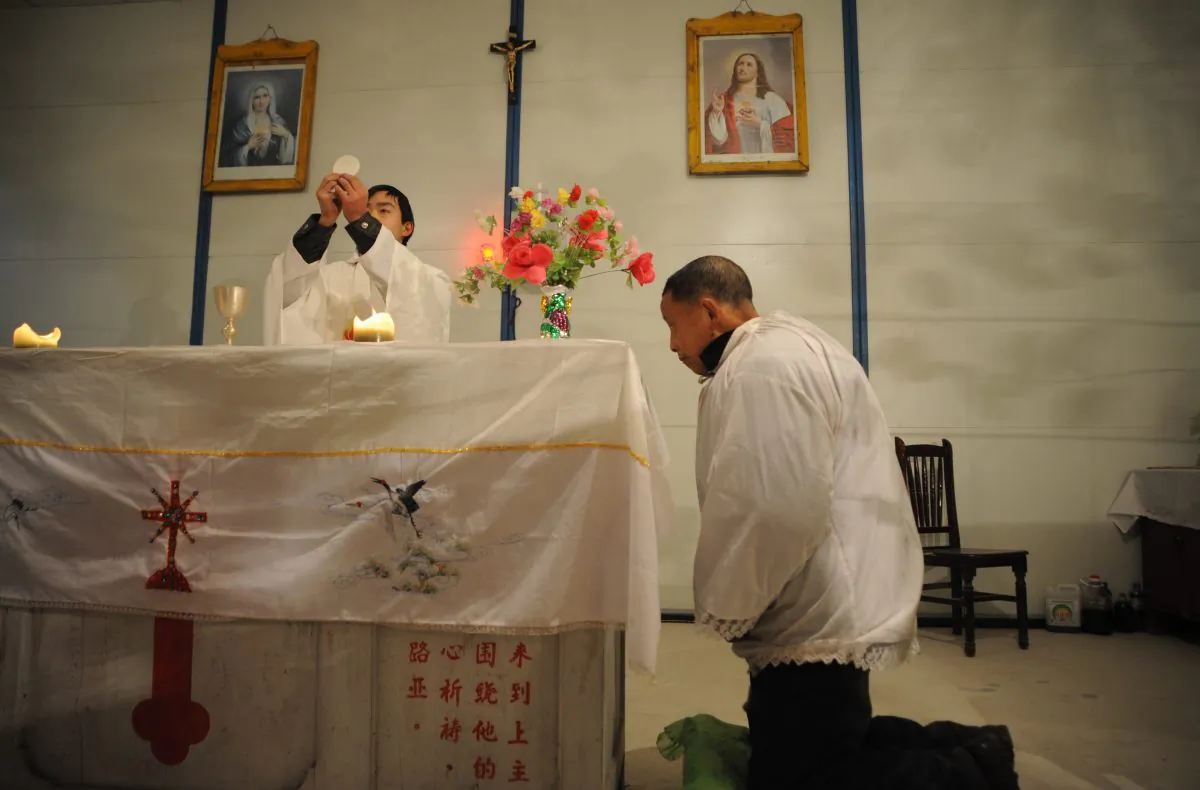 A priest prepares to offer Holy Communion during a Christmas Eve Mass at a house church in Pengzhou City, China, on Dec. 24, 2008. (China Photos/Getty Images)