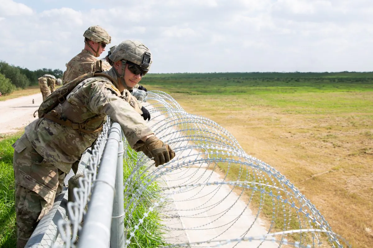 The U.S. military installs concertina wire on the existing levee wall behind Granjeno, Hidalgo County, Texas, just north of the U.S.–Mexico border on Nov. 7, 2018. (Samira Bouaou/The Epoch Times)