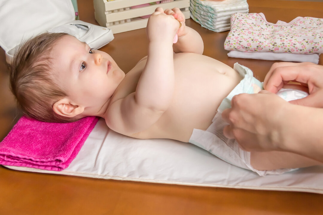 Stock image showing an adult changes a baby's diaper. (Shutterstock)