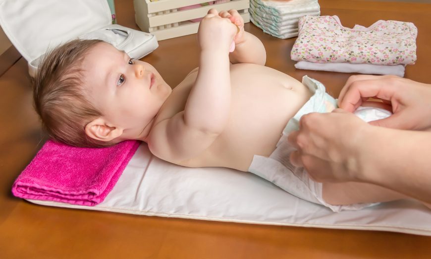 Stock image showing an adult changes a baby's diaper. (Shutterstock)