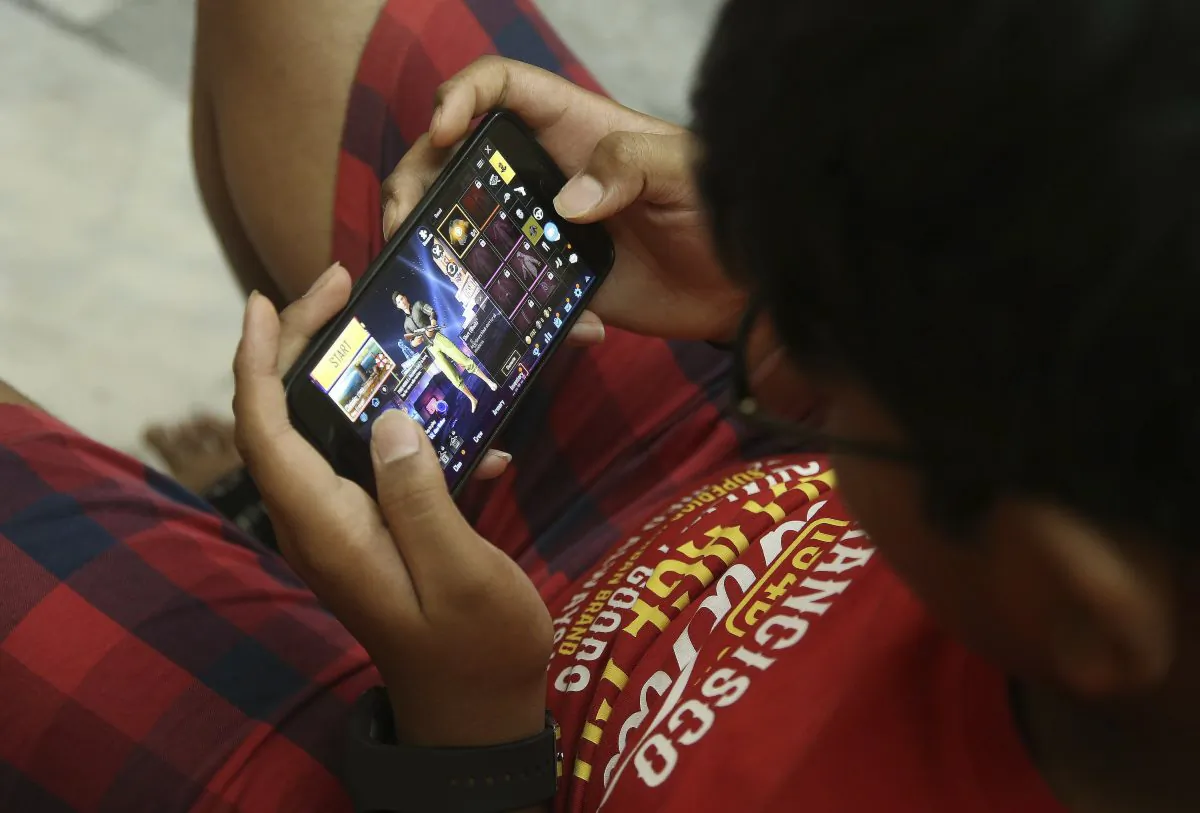 A boy plays a game on his mobile phone in Hyderabad, India, on April 5, 2019. (Mahesh Kumar A/Photo via AP)
