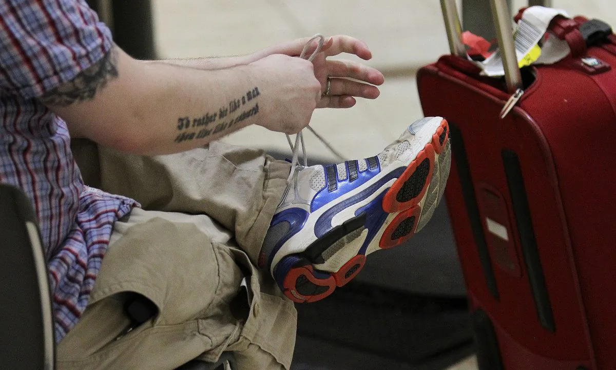An air traveler putting on his shoes. (David McNew/Getty Images)