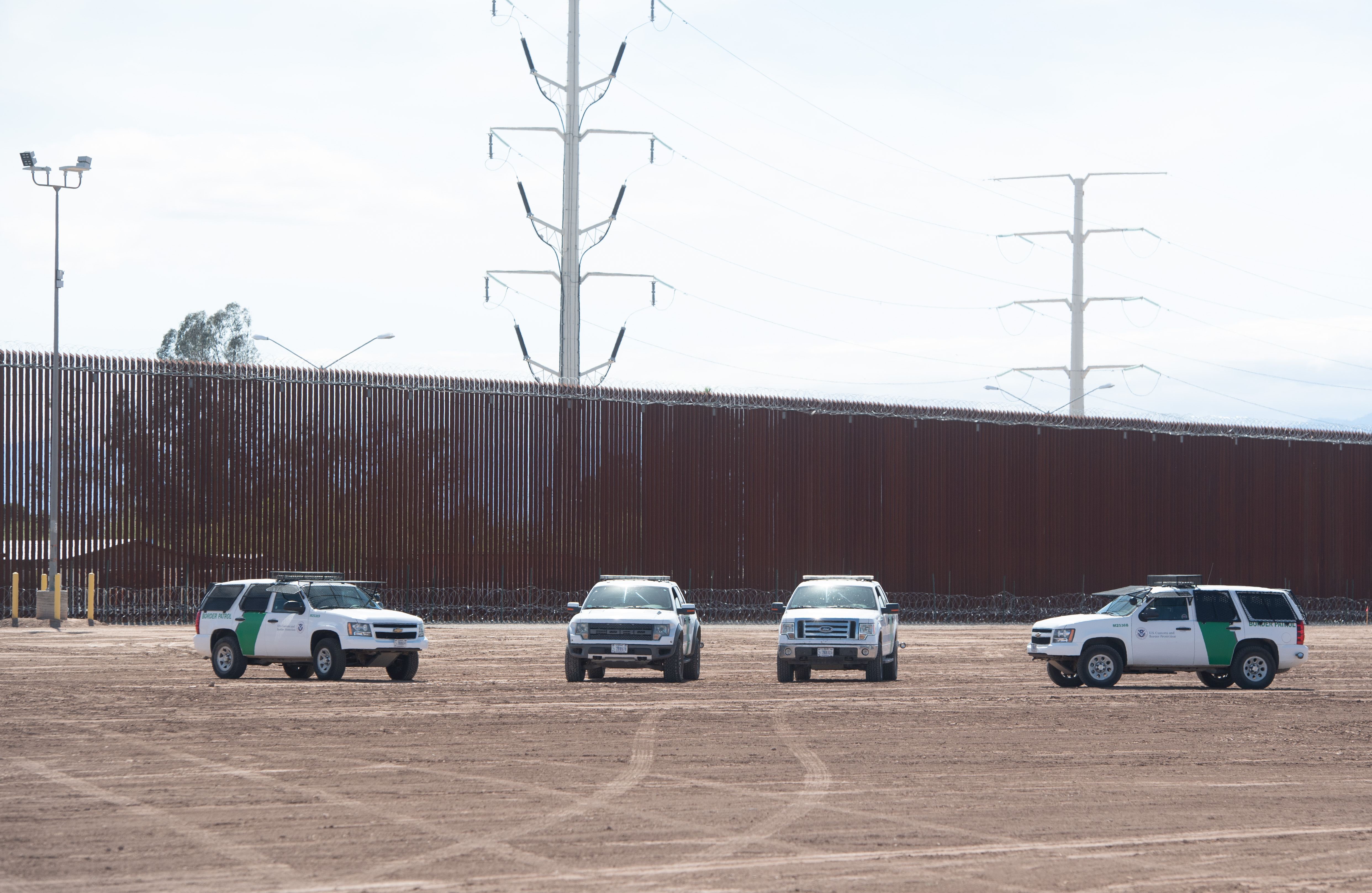 U.S. Customs and Border Patrol cars are seen near the border wall between the United States and Mexico in Calexico