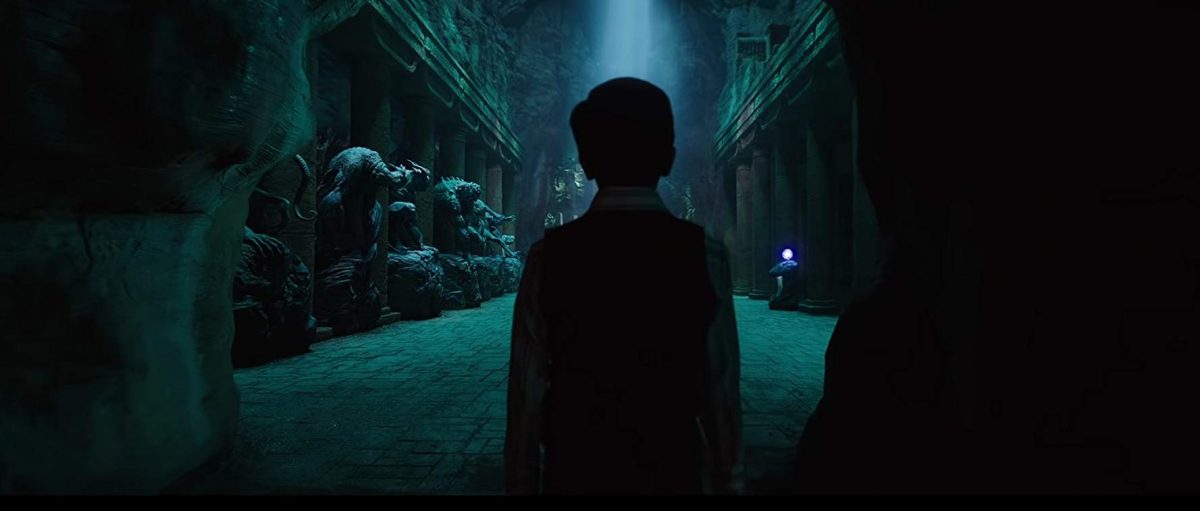 boy enters cave with demon statues