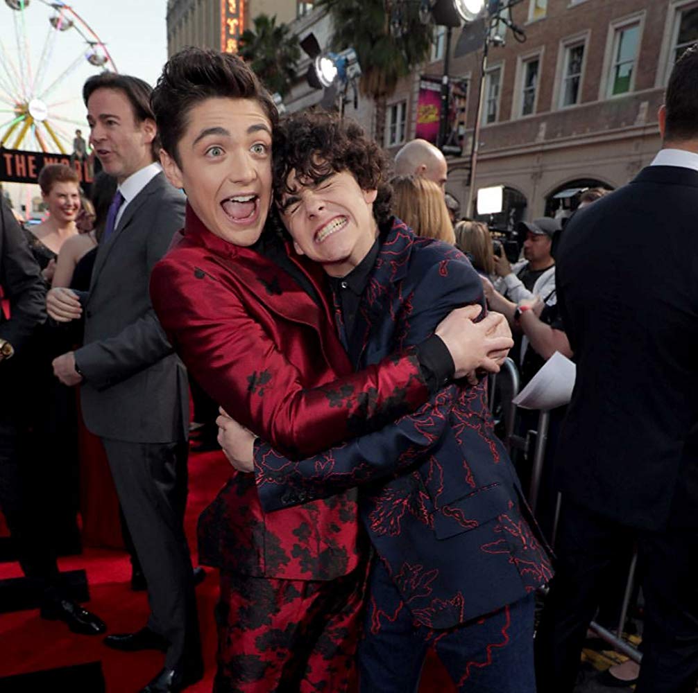 Two boys in suits having a happy hug