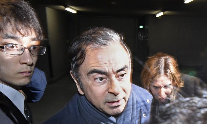 In this Wednesday, April 3, 2019, file photo, former Nissan Chairman Carlos Ghosn, center, leaves his lawyer's office in Tokyo. Tokyo prosecutors arrested Ghosn on Thursday, April 4, 2019 for a fourth time on fresh allegations that cut short his brief time outside detention. (Sadayuki Goto/Kyodo News via AP, File)