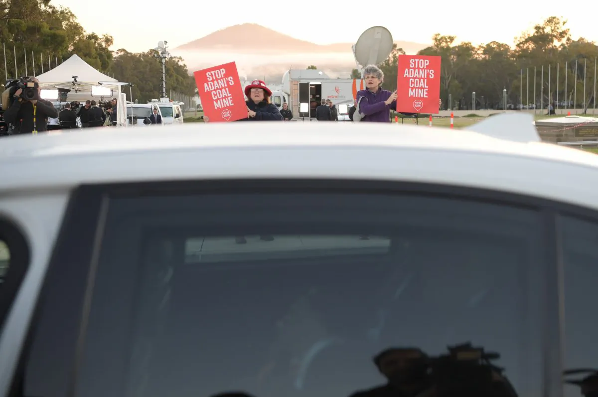 Anti Adani protesters shadow Prime Minister Scott Morrison as he leaves a television interview in front of Parliament House on April 3, 2019 in Canberra, Australia. (Tracey Nearmy/Getty Images)