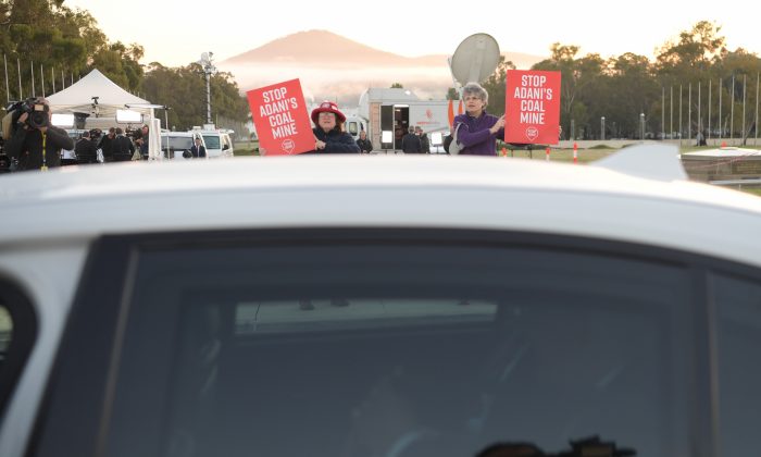 Anti Adani protesters shadow Prime Minister Scott Morrison as he leaves a television interview in front of Parliament House on April 3, 2019 in Canberra, Australia. (Tracey Nearmy/Getty Images)