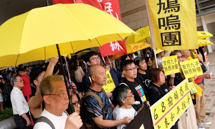 Pro-democracy supporters hold yellow umbrella to support leaders of Occupy Central activists, outside the court, in Hong Kong, China on April 9, 2019. (Tyrone Siu/Reuters)