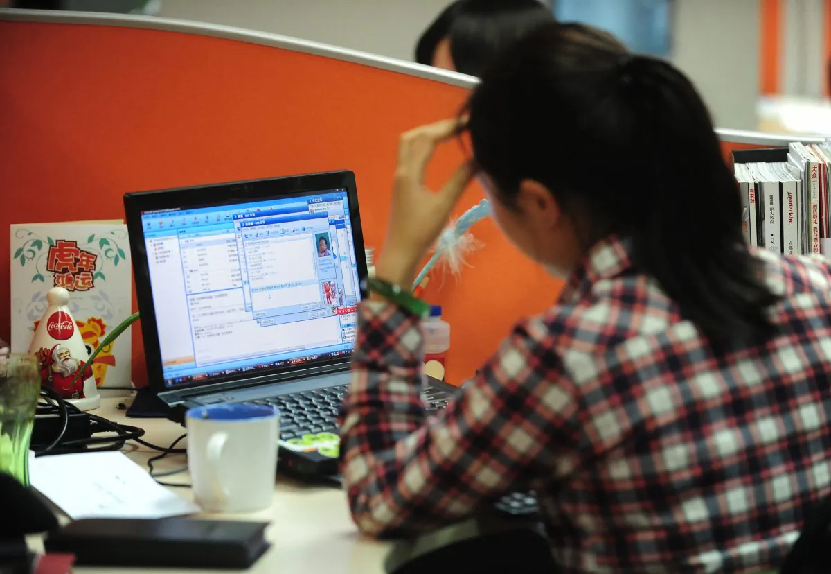 A woman works online in her cubicle at an office in Beijing on February 4, 2010. (FREDERIC J. BROWN/AFP/Getty Images)