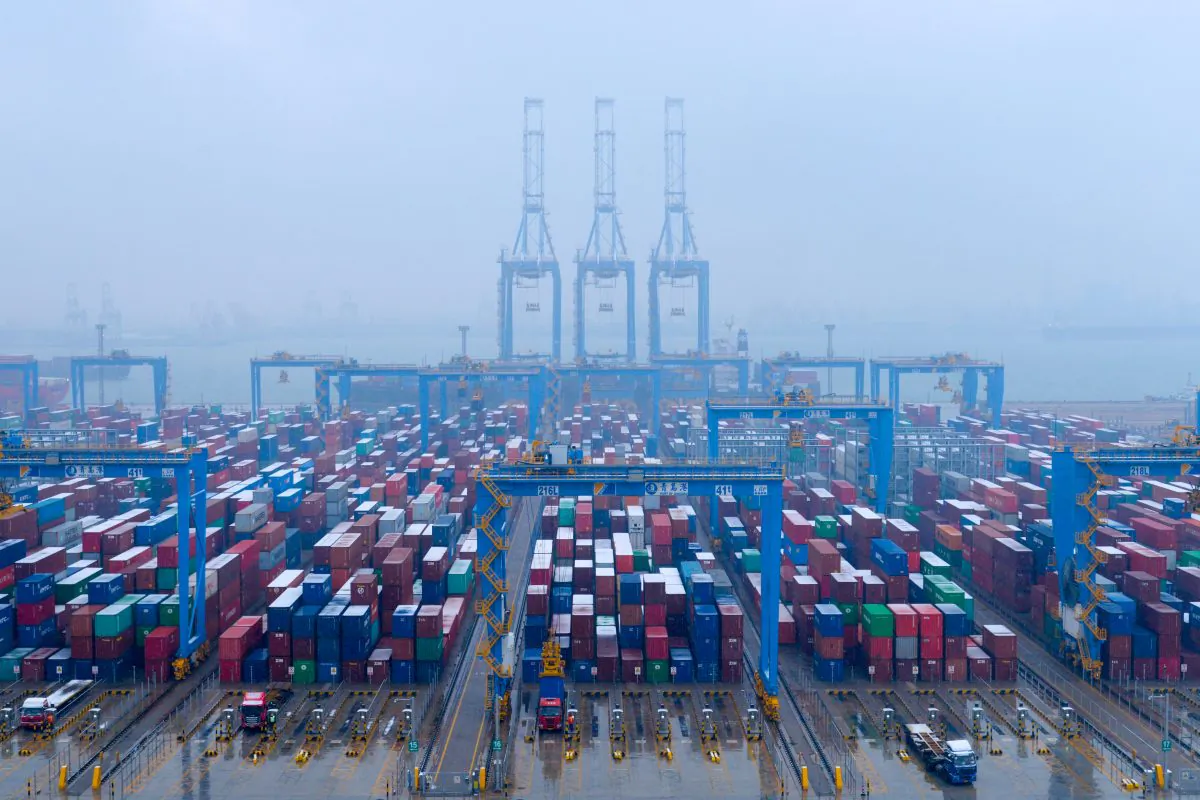 Containers and trucks are seen on a snowy day at an automated container terminal in Qingdao port, Shandong Province, China on Dec. 10, 2018. (Reuters)
