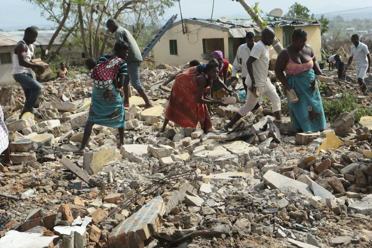 Women and men pick up bricks from a collapsed house to build another structure in Beira, Mozambique, on March, 31, 2019. (Tsvangirayi Mukwazhi/Photo via AP)