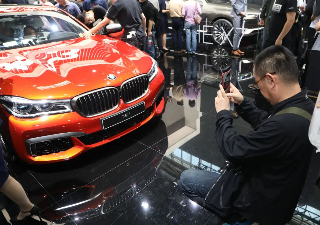 A man takes a picture of a BMW "THE 7" during the first public opening day at the Beijing auto show in Beijing on April 27, 2018. (AFP/Getty Images)