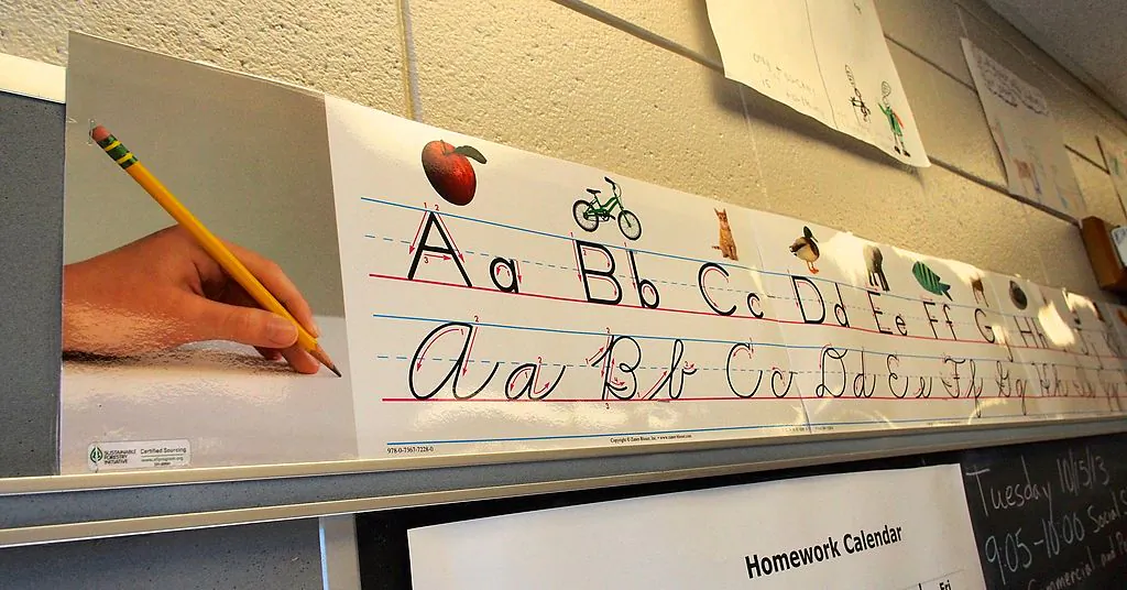 A poster showing third-grade pupils how to write in printed and cursive letters runs across the top of a blackboard at an elementary school in Ellicott City, Maryland on October 15, 2013. (Robert MacPherson/AFP/Getty Images)