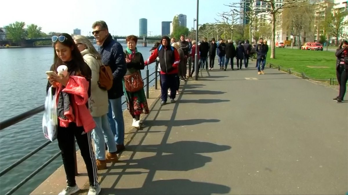 Passers-by gathering along Main river to witness the underwater defusing of an WWII bomb in Main River, in Frankfurt, Germany