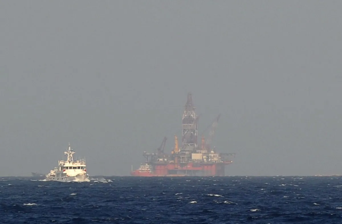 A Chinese coast guard vessel (L) sails near China's oil drilling rig in disputed waters in the South China Sea on May 14, 2014. (HOANG DINH NAM/AFP/Getty Images)