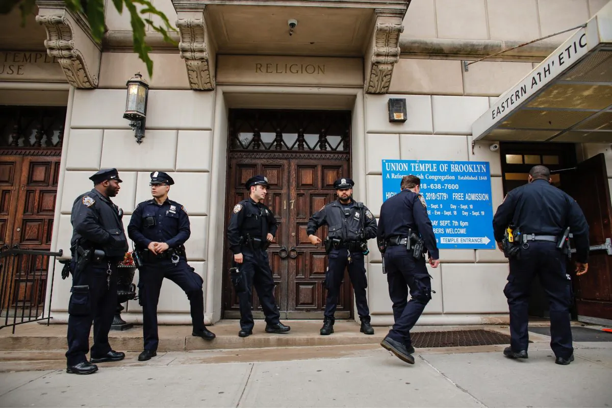 NYPD officers stand guard at the door of the Union Temple of Brooklyn in New York on Nov. 2, 2018. Police determined that anti-Semitic graffiti found inside a Brooklyn synagogue was scrawled by a former city council intern. (Kena Betancur/AFP/Getty Images)